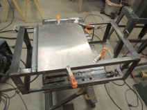Welded steel heater exhaust heat shield to driver side under subframe storage box mount